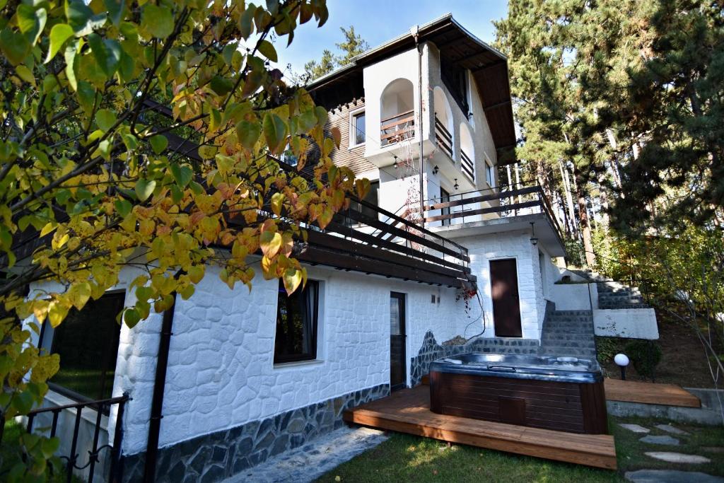 韦林格勒Spa Villa Galileev的白色砖屋,前面设有木甲板