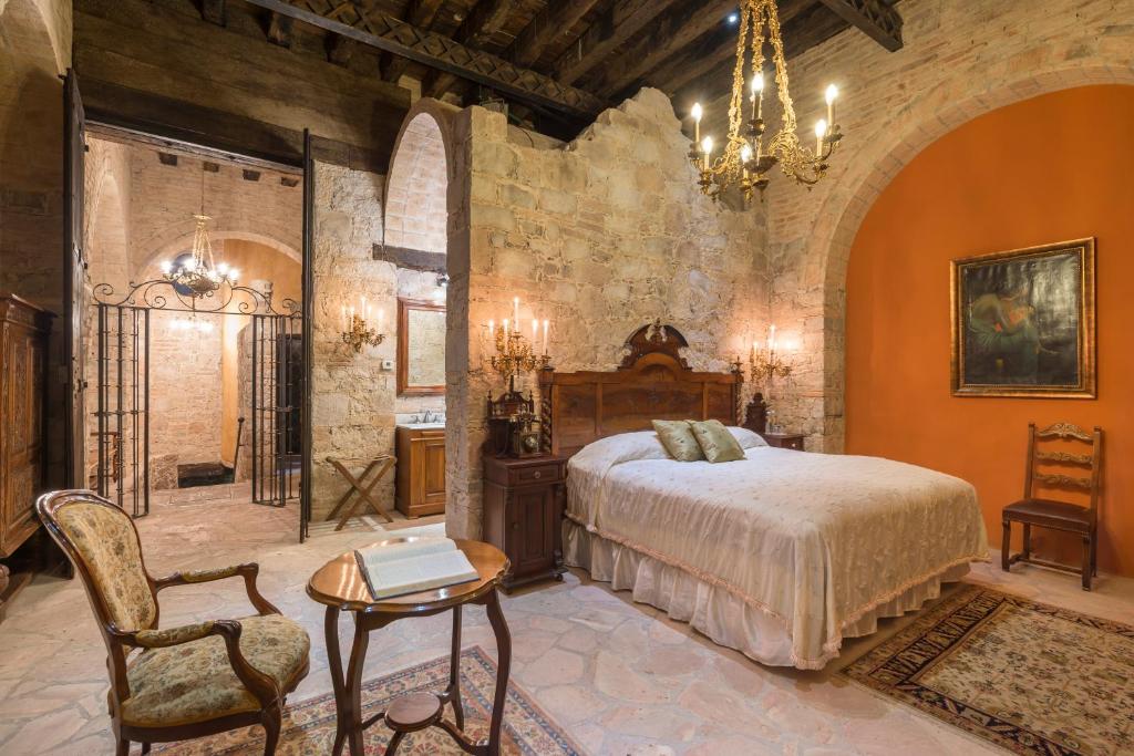 圣路易斯波托西Hotel Museo Palacio de San Agustin的一间卧室配有一张床、一张桌子和一个吊灯。
