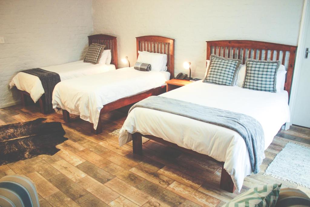 科尔斯伯格Merino Inn Hotel的铺有木地板的客房内的两张床