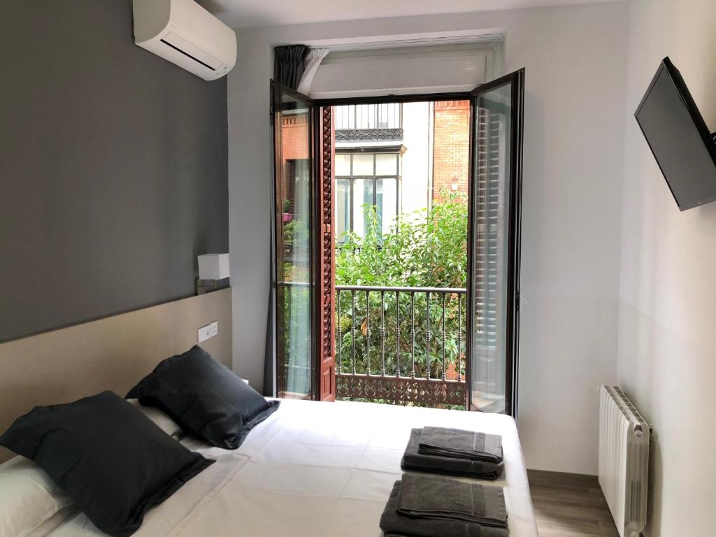 马德里马德里阿托查旅馆的一间卧室设有一张床和一个大窗户
