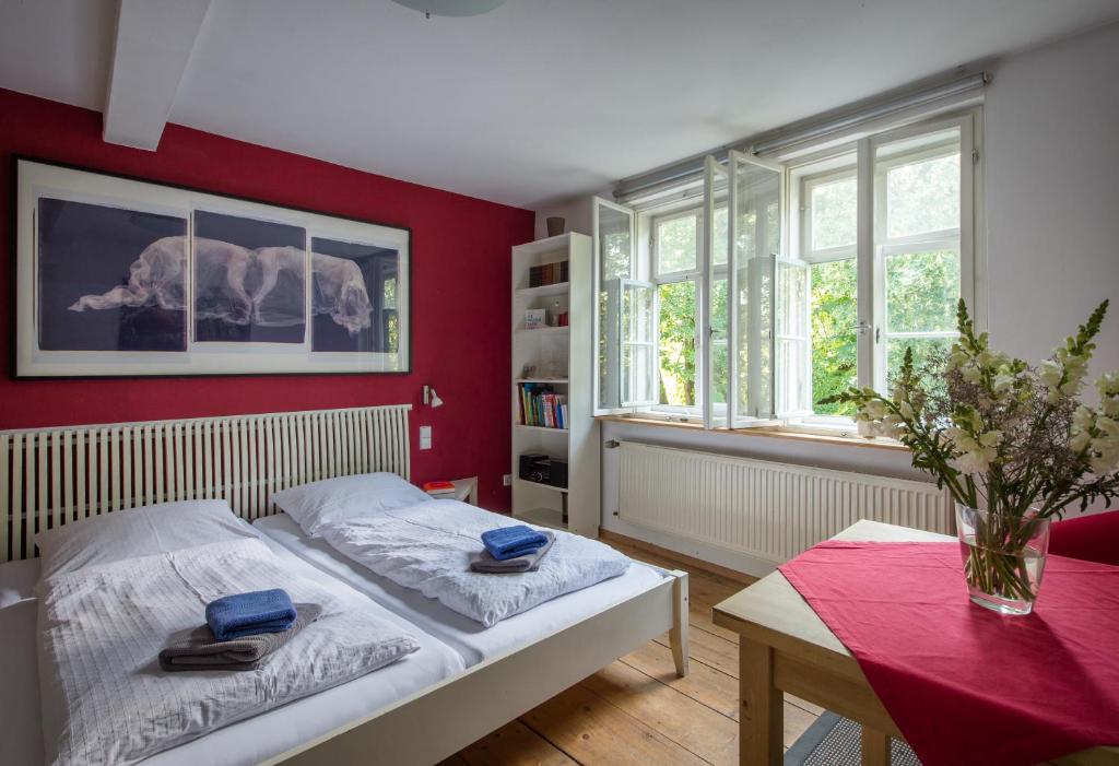 魏玛"goethezimmer" Ferienwohnung und Zimmer am Burgplatz的卧室设有红色的墙壁、一张床和一张桌子