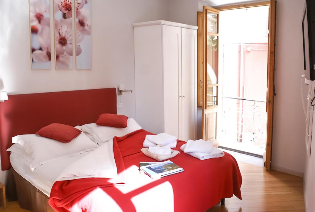 卡利亚里Numero 3的一间卧室配有一张带红白毯子的床