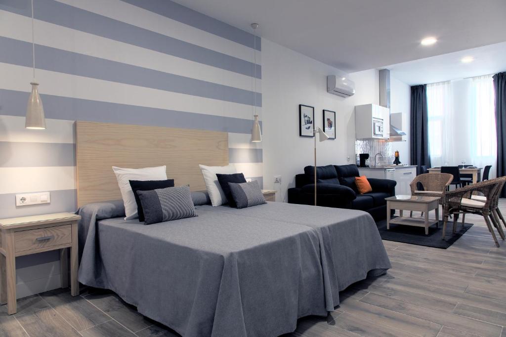 梅里达MPD公寓式酒店的一间卧室设有一张床和一间客厅。