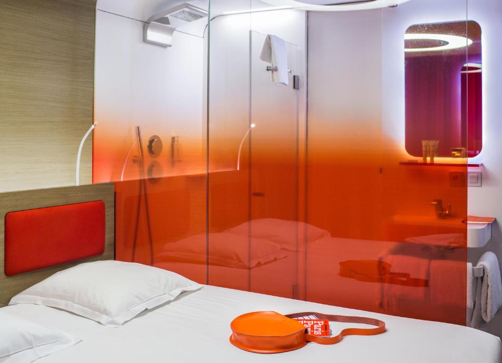 巴黎Hôtel Odyssey的一间带玻璃淋浴间和一张床的卧室