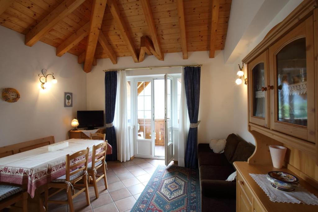 莫尔韦诺Casa Rubino Lake & Dolomites的一间带桌椅的客厅和一间房间