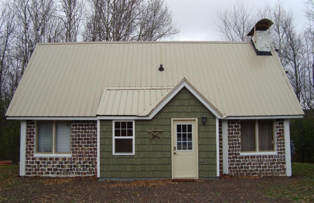 BessemerHusky House的一座带屋顶和门的绿色小房子