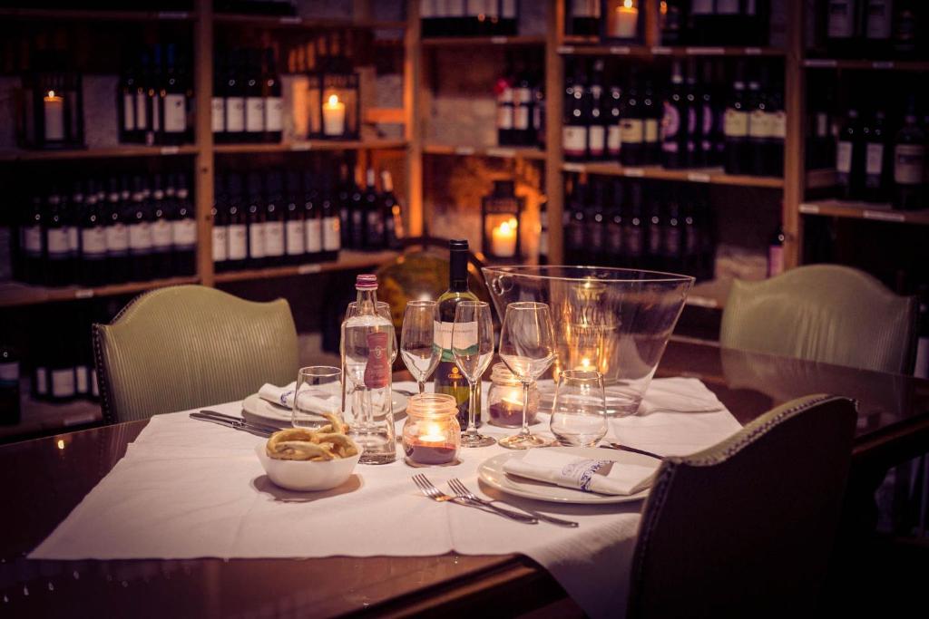 瓦拉洛蓬比亚拉培拉酒店餐厅的酒窖里的桌子,里面装有酒瓶和酒杯