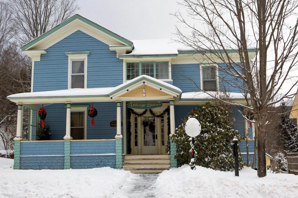 Margaretville乡村套房酒店的蓝色房子前面有圣诞花圈