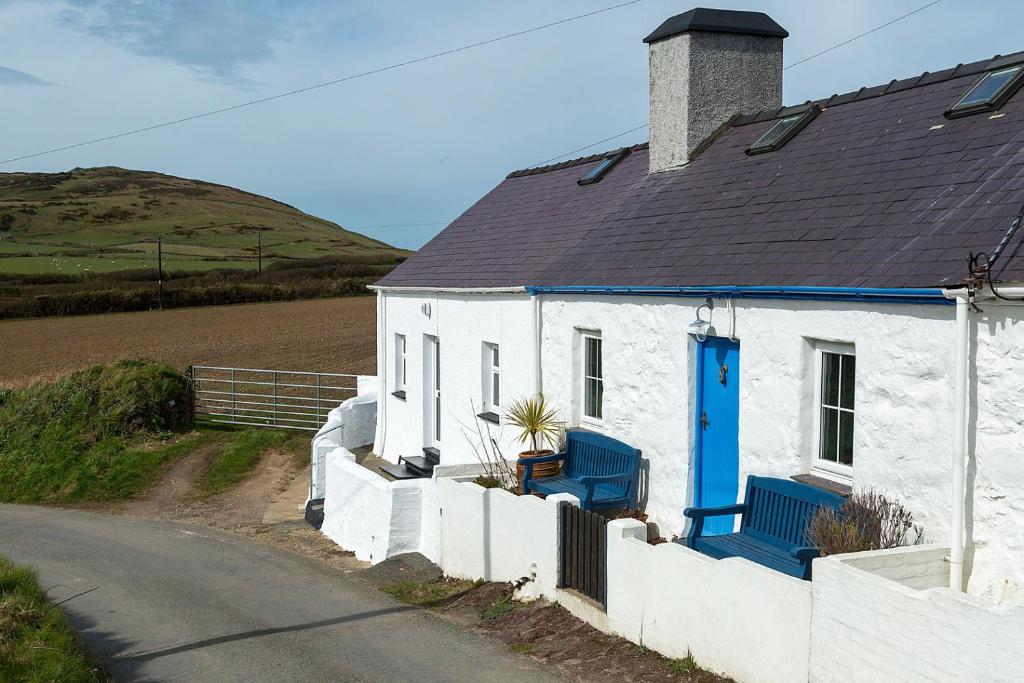 阿贝达隆Aberdaron Cottage 2 Bryn Chwilog的白色的房子,有蓝色的门和一条路