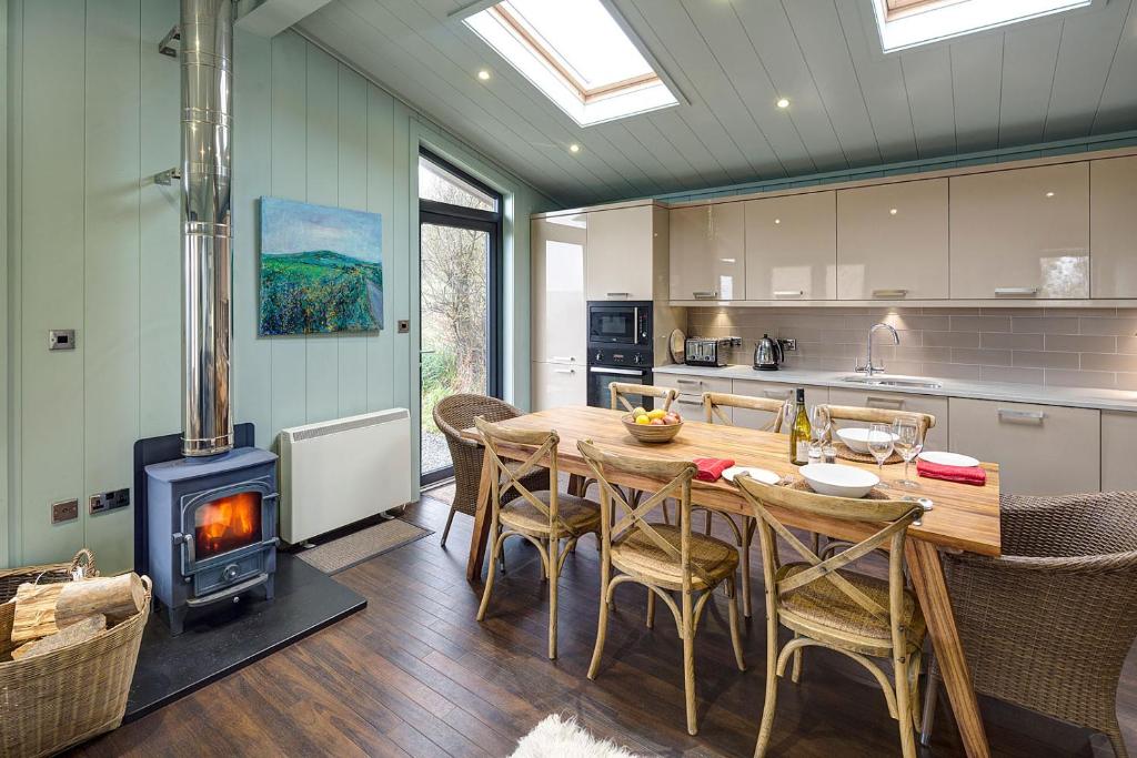阿贝达隆Aberdaron Lodge的厨房配有木桌和燃木炉。