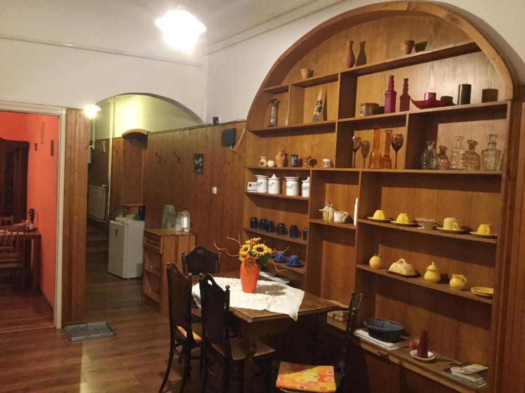 埃格尔巴齐利卡文德哈兹旅馆的用餐室配有桌子和带鞋架的书架