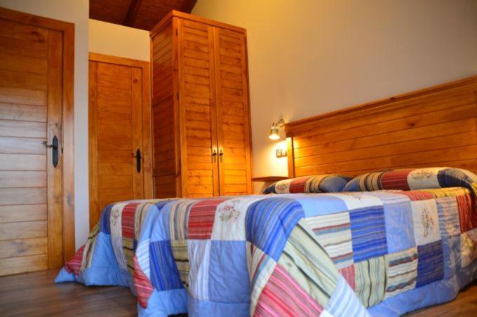CaunedoCasa Peñavera-Somiedo的一间卧室配有一张带木制床头板的床