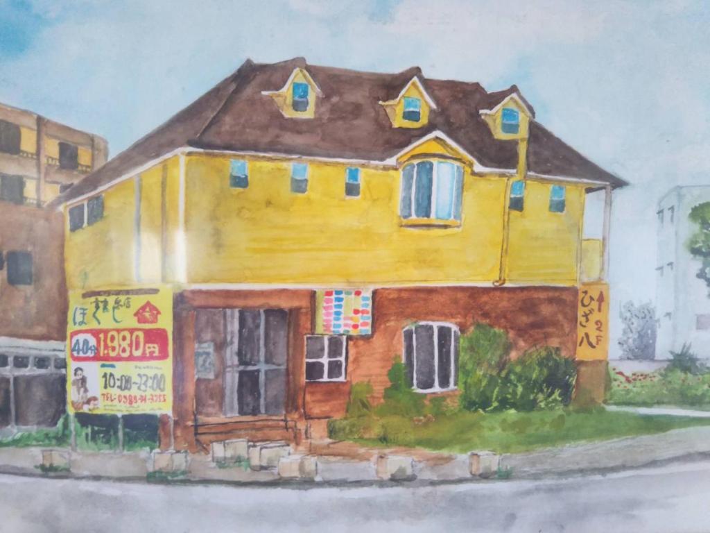 宫古岛宮古島サイクリストの宿的街道上一幅黄色房子的画