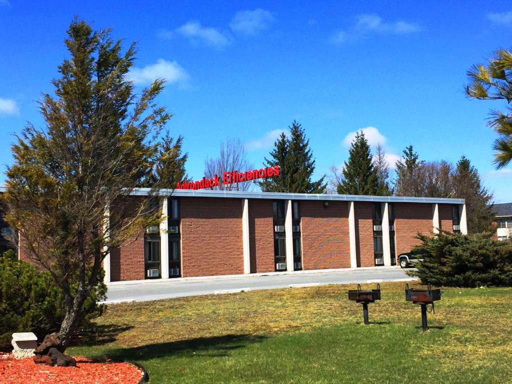 沃特敦Adirondack Efficiencies的一座大砖砌建筑,上面有红色标志