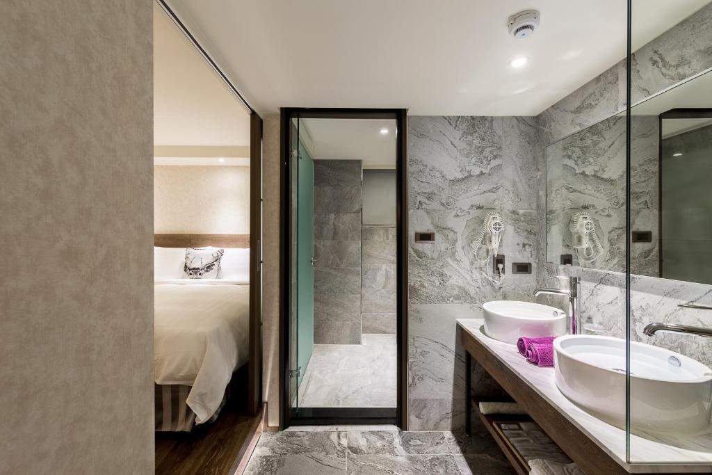 嘉义市兰桂坊花园酒店的一间带两个盥洗盆和淋浴的浴室以及一张床