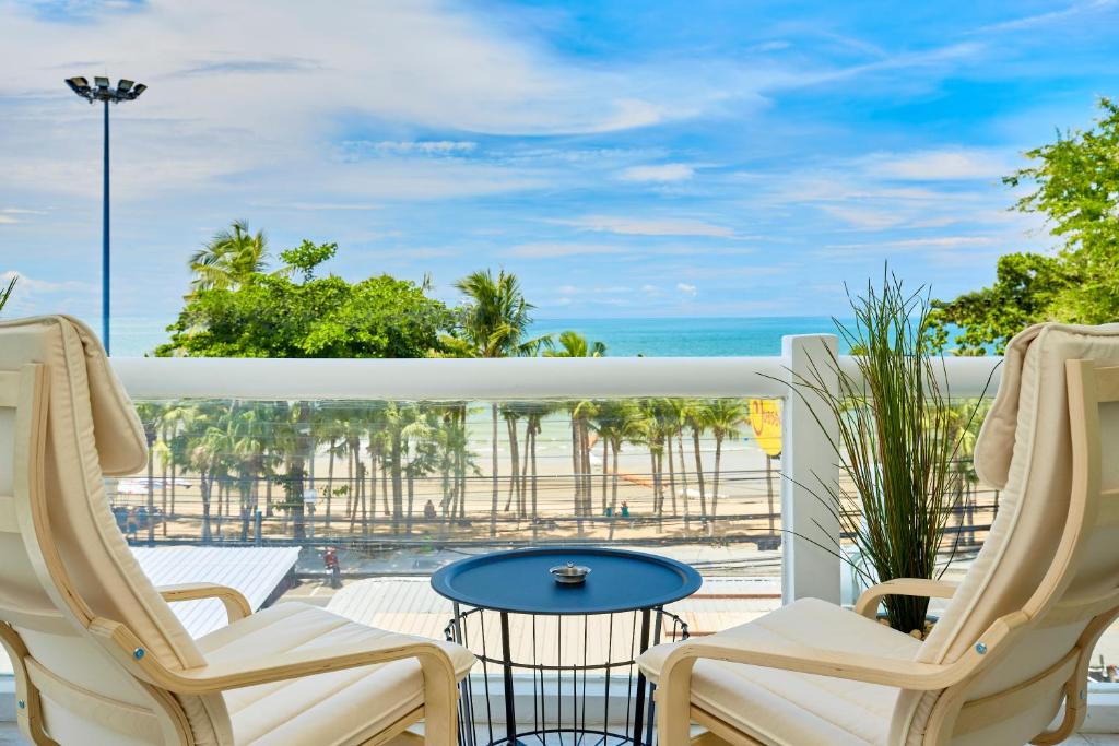 乔木提恩海滩LUXURIOUS APARTMENT at VILLA NAVIN, 30's JOMTIEN BEACH的一个带桌椅的海景阳台