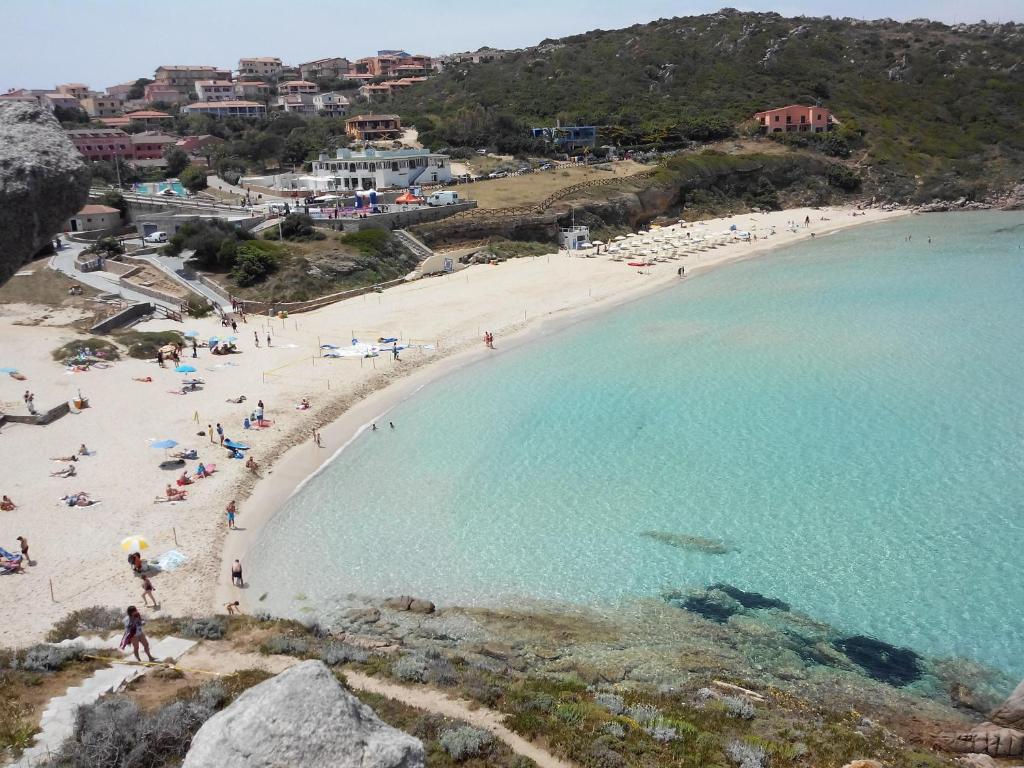 圣特雷莎加卢拉Luminoso bilo vista mare con wi fi a 150 mt da Rena Bianca的沙滩上和一群人一起在沙滩和水面上