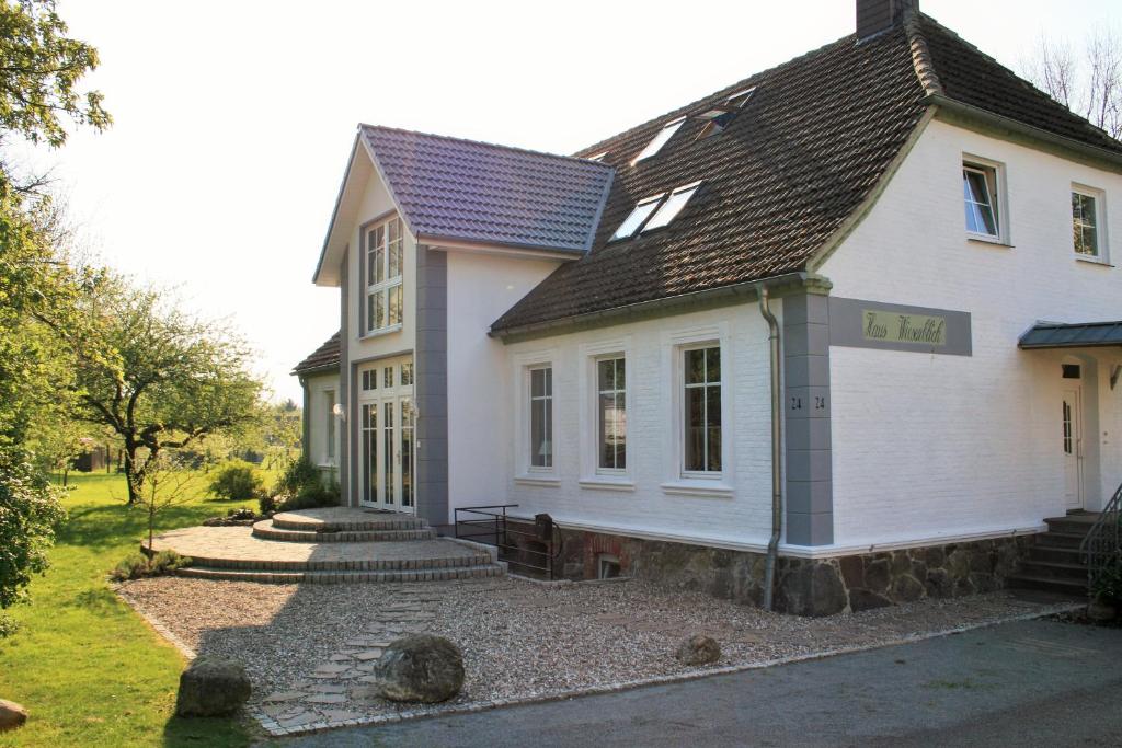 博尔滕哈根Haus Wiesenblick的白色房子,有板岩屋顶