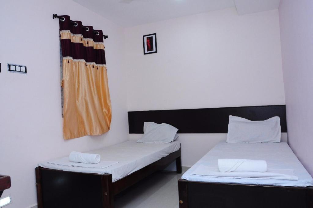 蒂鲁帕蒂SGS Residency的客房设有两张床和窗户。