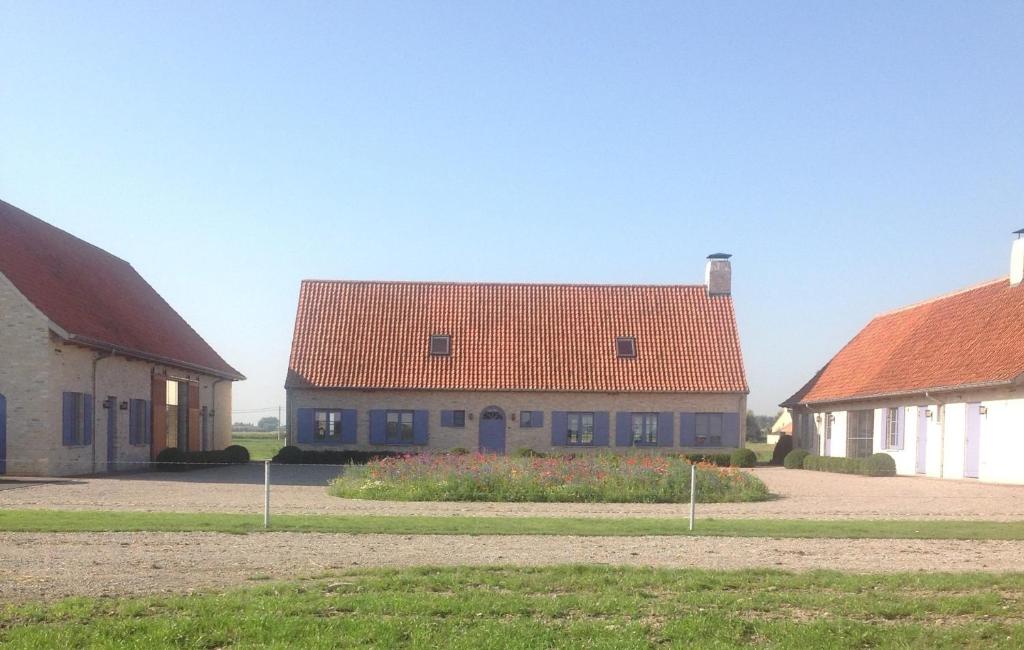 迪克斯梅德De Goudmijn的一座红色屋顶的房子和两栋建筑