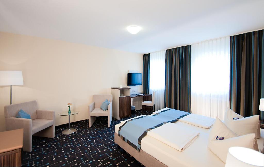 Pliening库尼格酒店的配有一张床和一张书桌的酒店客房