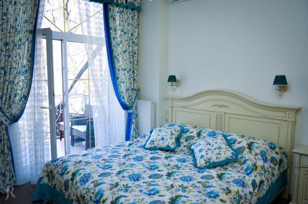 敖德萨Hotel MAMAN的卧室配有带枕头的床铺和窗户。