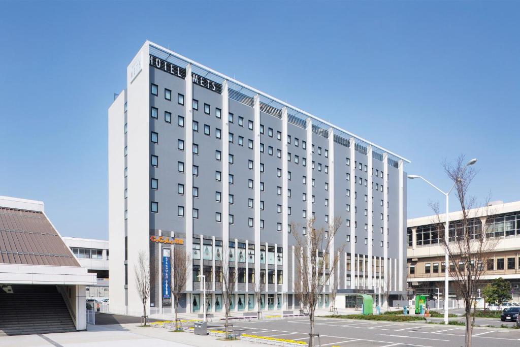 新泻JR-EAST Hotel Mets Niigata的一条城市街道上的白色大建筑