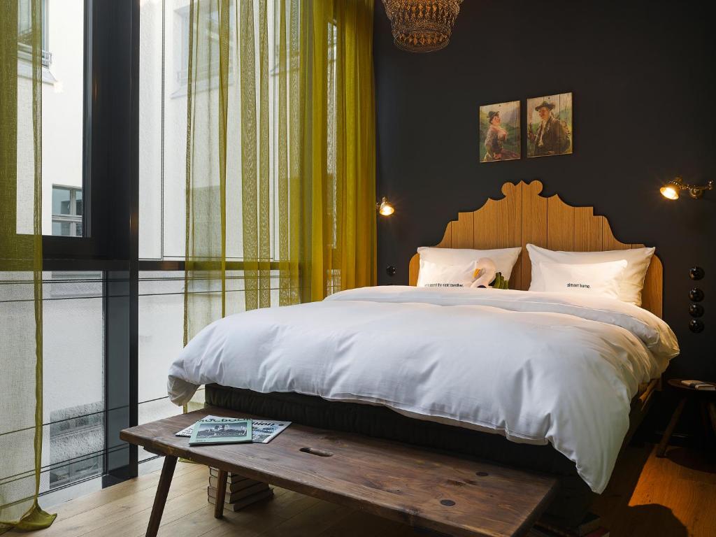 慕尼黑25小时巴伐利亚皇家酒店的一间卧室配有一张大床和一张木桌