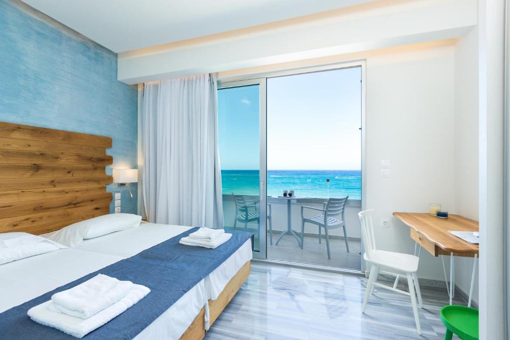 罗希姆诺Meltemi Coast Suites的一间卧室配有一张床,享有海景