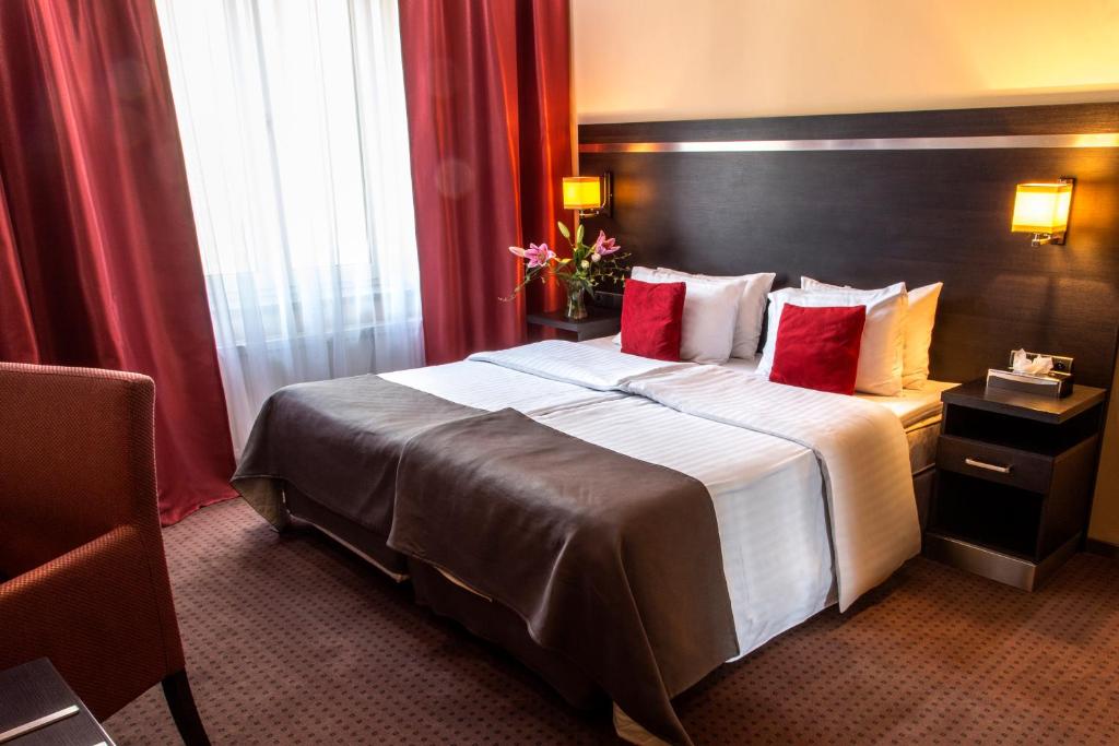杰尔若纽夫德尔塔因酒店的酒店客房,设有一张带红色窗帘的大床