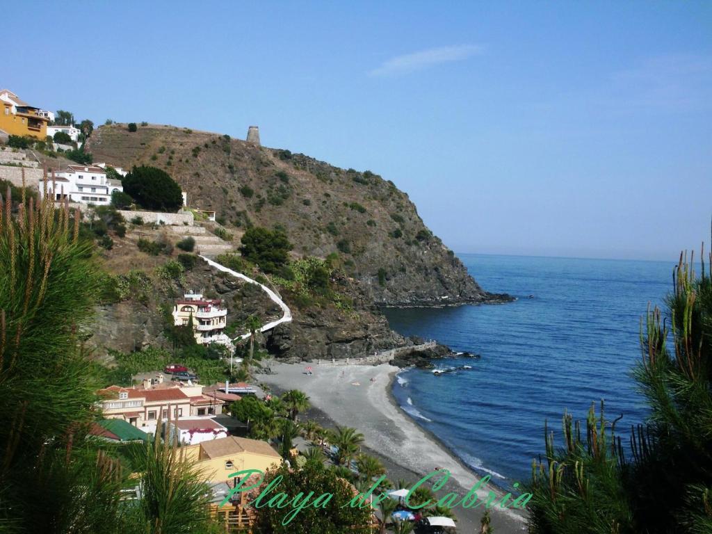 阿尔姆尼卡Castillo del Mar的海边小山上的海滩,有房子