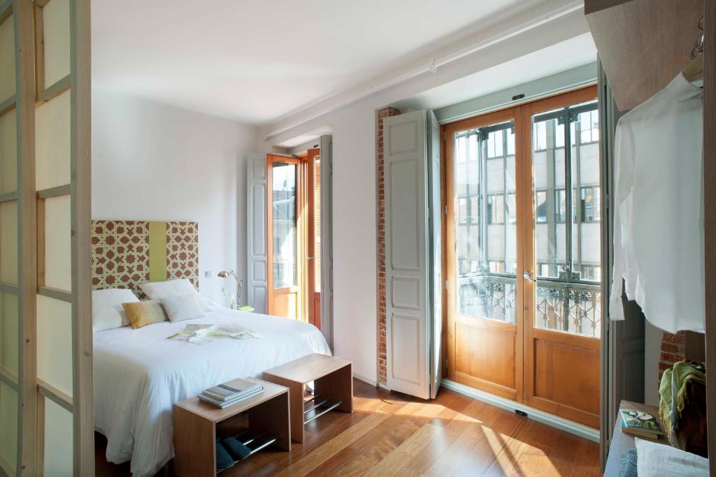 马德里埃里克佛克尔精品公寓酒店 - 马德里套房的卧室配有白色的床和窗户。