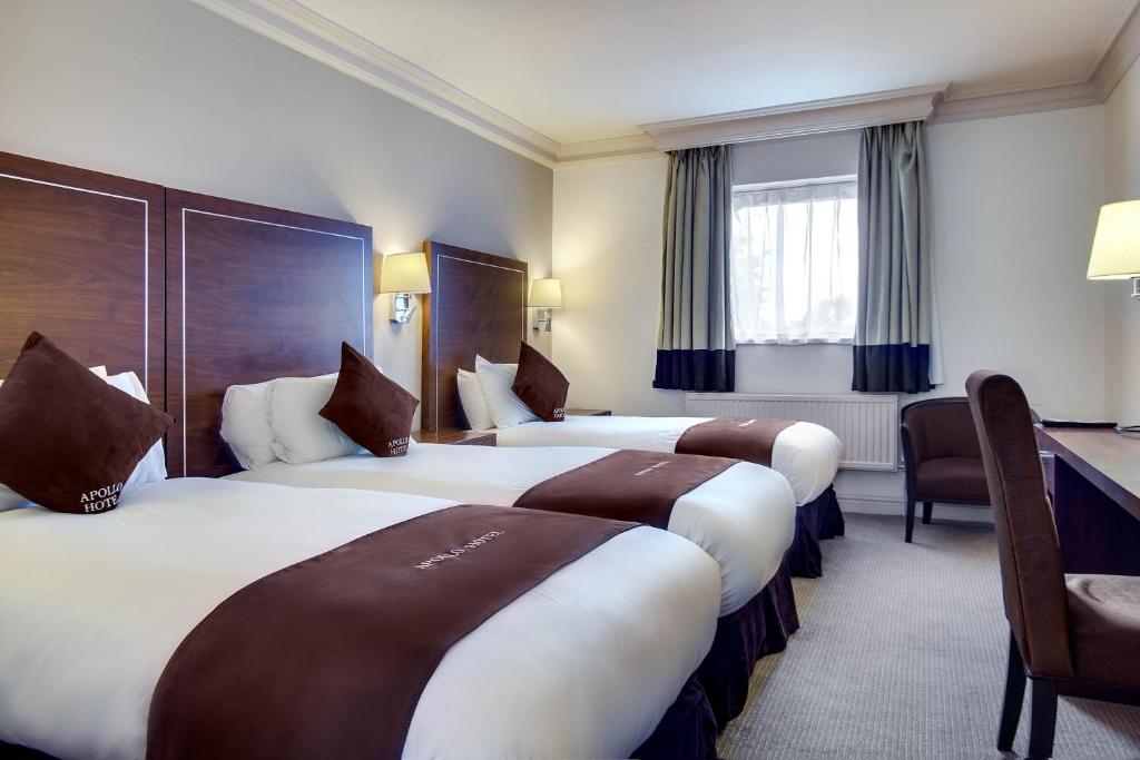 伯明翰阿波罗酒店的酒店客房设有三张床和一张书桌