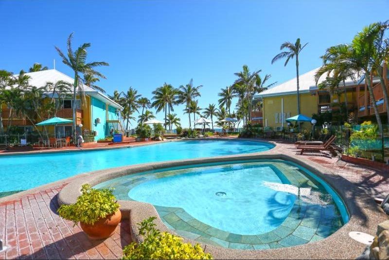 麦凯WhitsunStays - The Resort by the Sea的棕榈树度假村内的大型游泳池