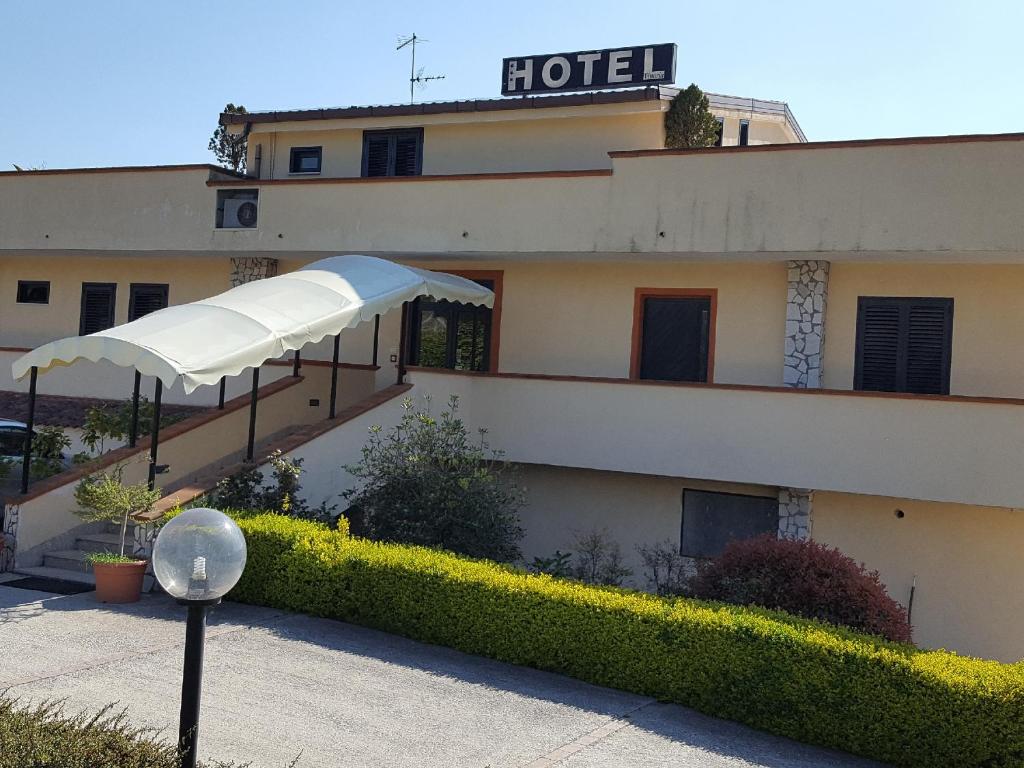 贝内文托维托瑞亚酒店的一座拥有白色遮阳伞的建筑的酒店