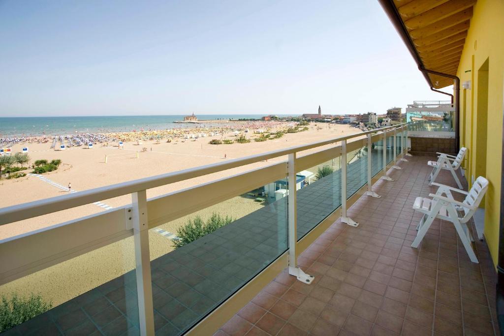 卡奥莱奥尔加别墅酒店的阳台配有两把白色椅子和海滩