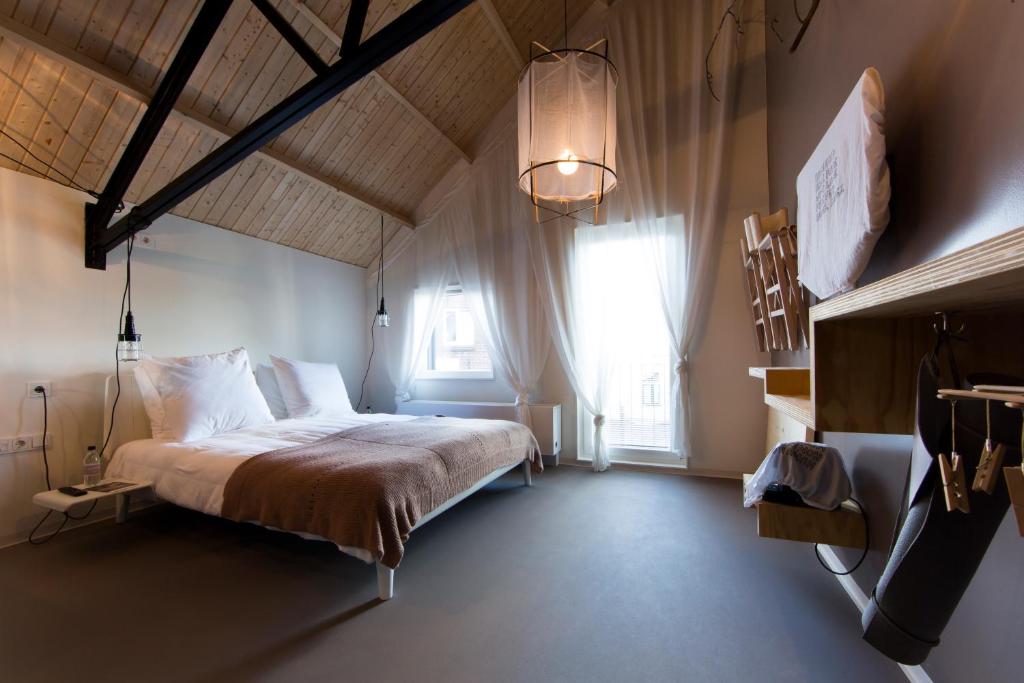阿纳姆莫得兹名家设计酒店 的一间卧室设有一张床和一个大窗户