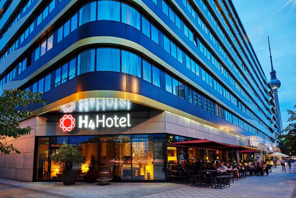 柏林柏林亚历山大广场H4酒店 的一座大型建筑,上面有h酒店标志