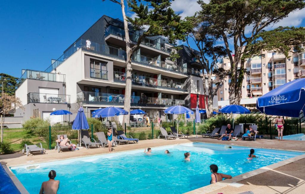 波尔尼谢Résidence Prestige Odalys De La Plage的一座游泳池位于酒店前,里面的人