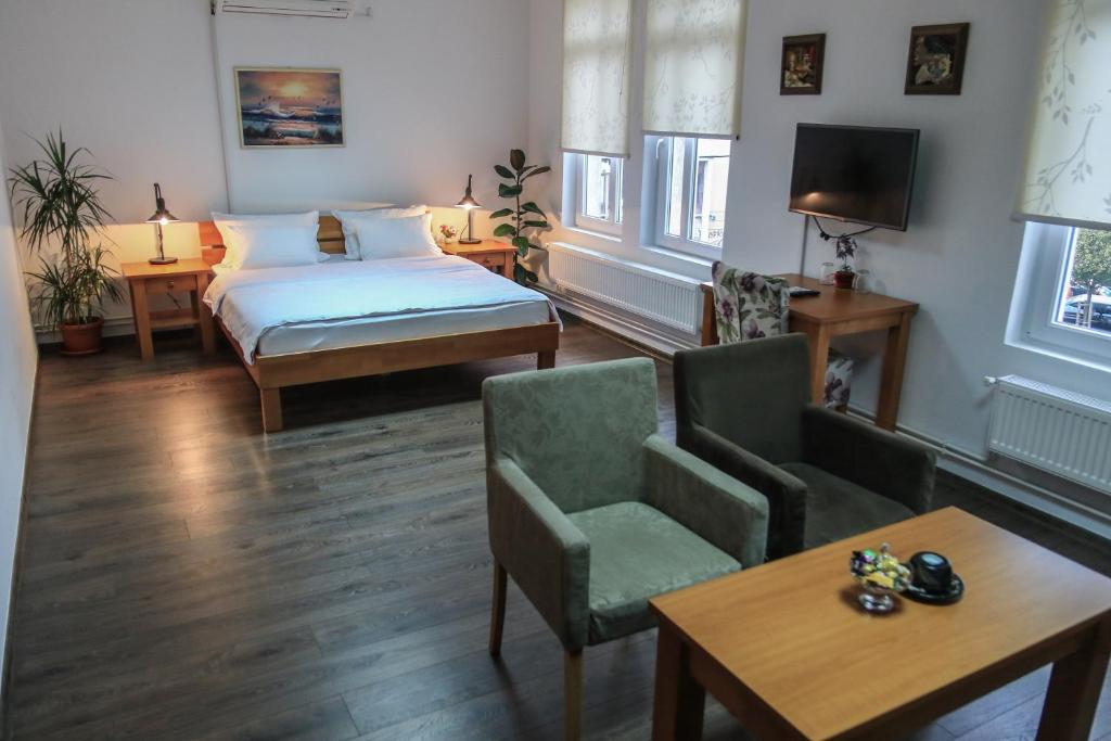 图兹拉Pansion Centar的酒店客房带一张床、一张桌子和椅子