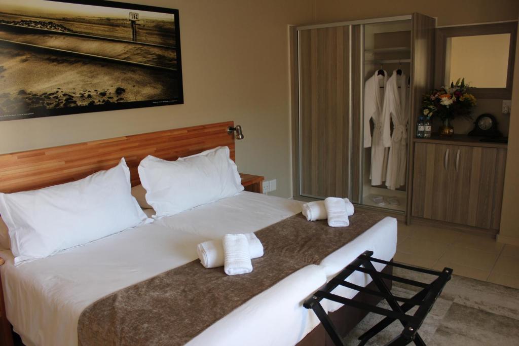斯瓦科普蒙德普罗斯特斯瓦科普蒙德纳米比亚酒店的卧室配有带毛巾的大型白色床