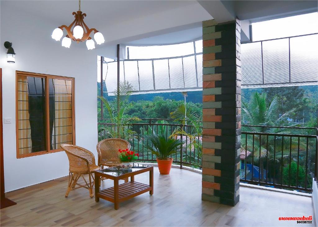 提喀迪Holiday Villa的一间带桌椅的客厅和一个阳台