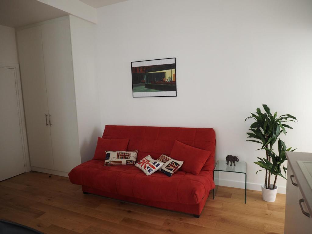 斯特拉斯堡Appartement place Golbéry的客厅里一张红色的沙发