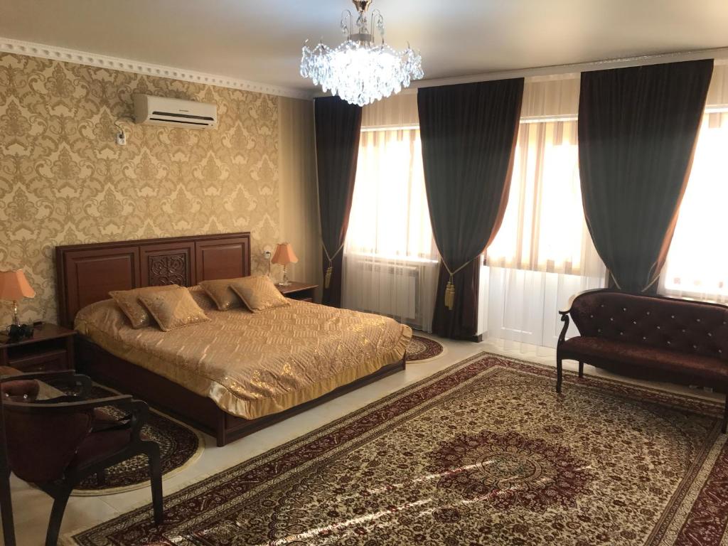 奎兹洛达Gostinitsa Grand的一间卧室配有一张床和一个吊灯