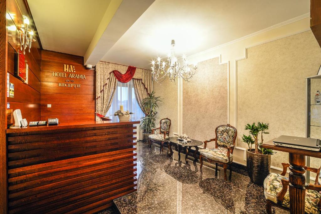 萨图马雷Hotel Aramia的一间设有桌椅的等候室