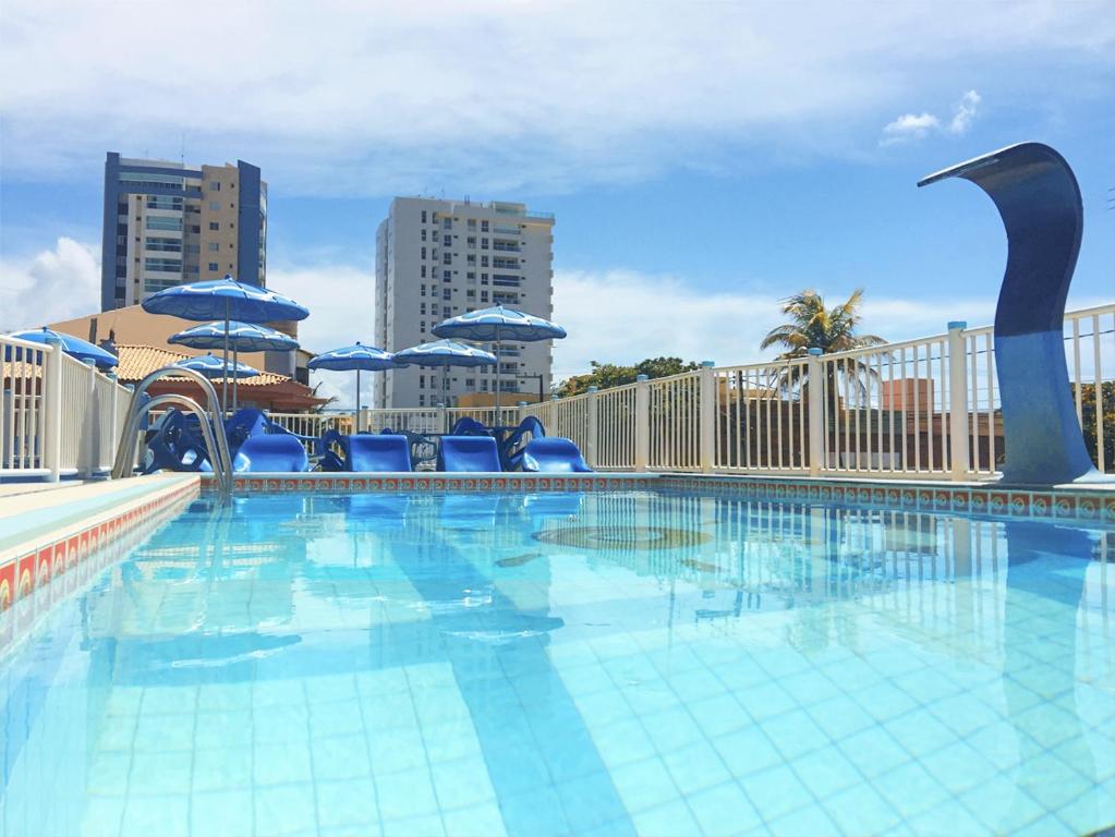 阿拉卡茹雷奥德索尔酒店的一个带蓝色椅子和遮阳伞的大型游泳池