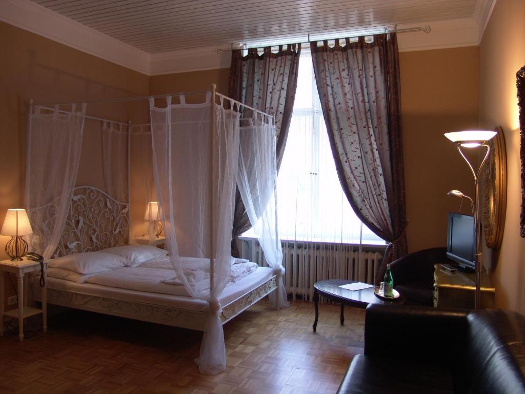柏林奥利维尔广场梅歇尔酒店的一间卧室设有天蓬床和窗户。