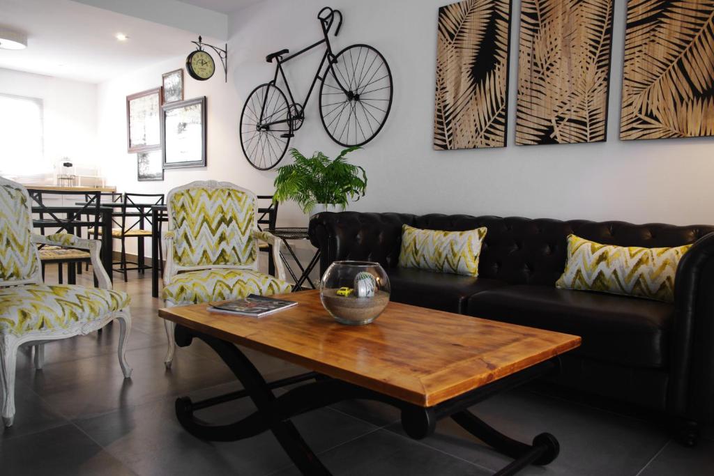 宏达海滩MAGMA Rooms Playa Honda的客厅配有沙发和桌子,墙上有自行车