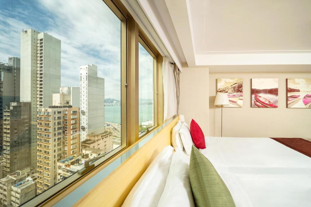 香港颐庭酒店的一间卧室设有一张床和一个大窗户