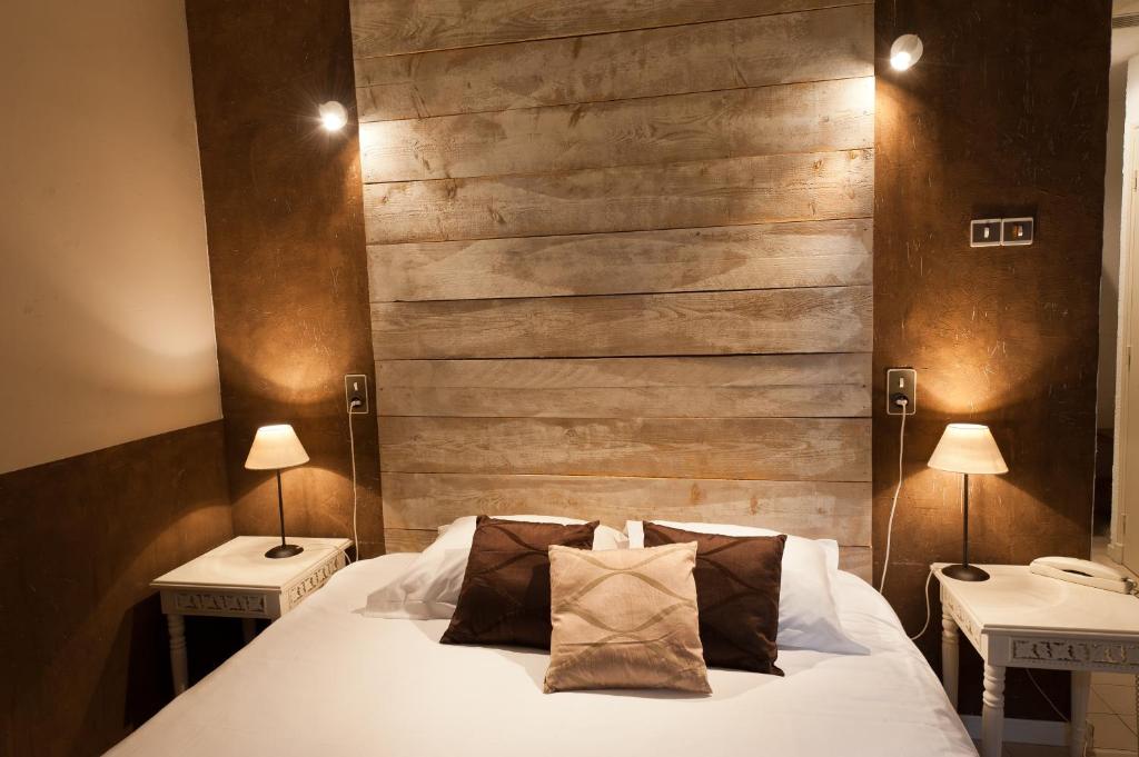 科尔尼永孔福勒迪维姆德米亚皮酒店的一间卧室配有一张带两张桌子和两盏灯的床。